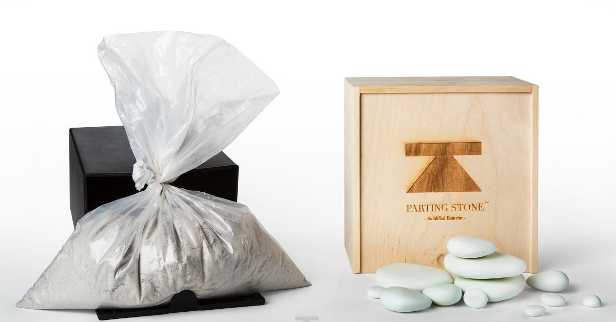 Bag of cremated human ash remains next to a wooden box and solidified human remains from Parting Stone